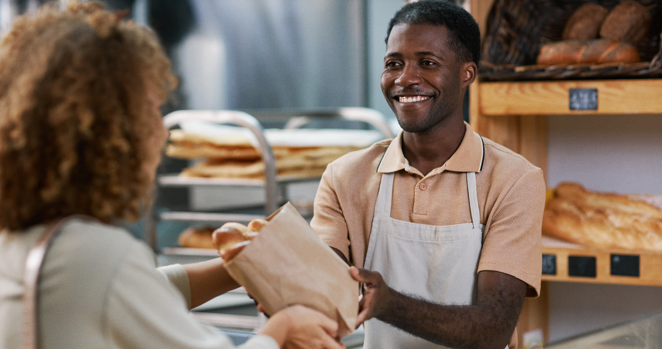 A baker helping a customer scan at the bakery counter