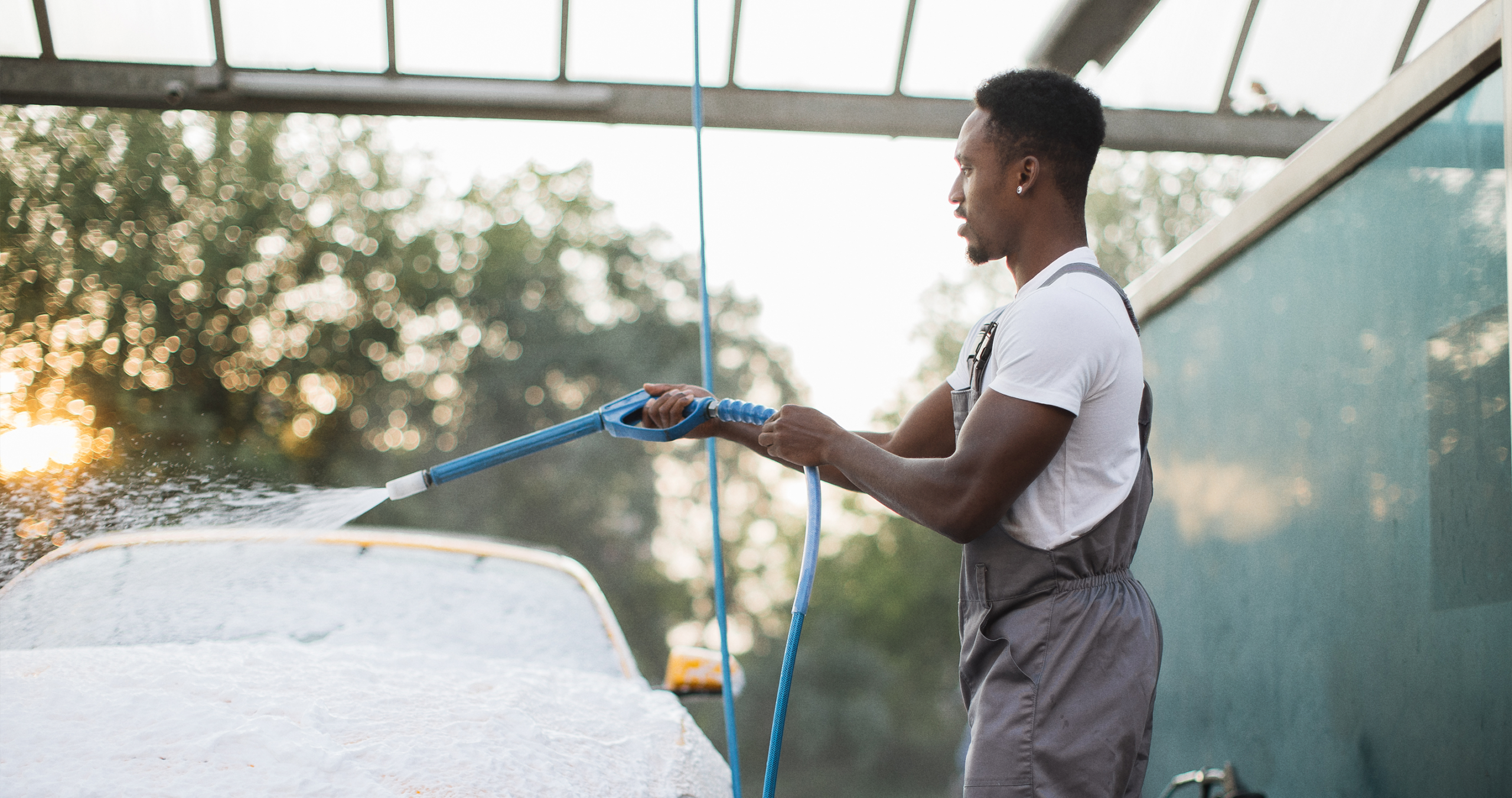A car wash attendant scanning a driver's phone at the wash bay