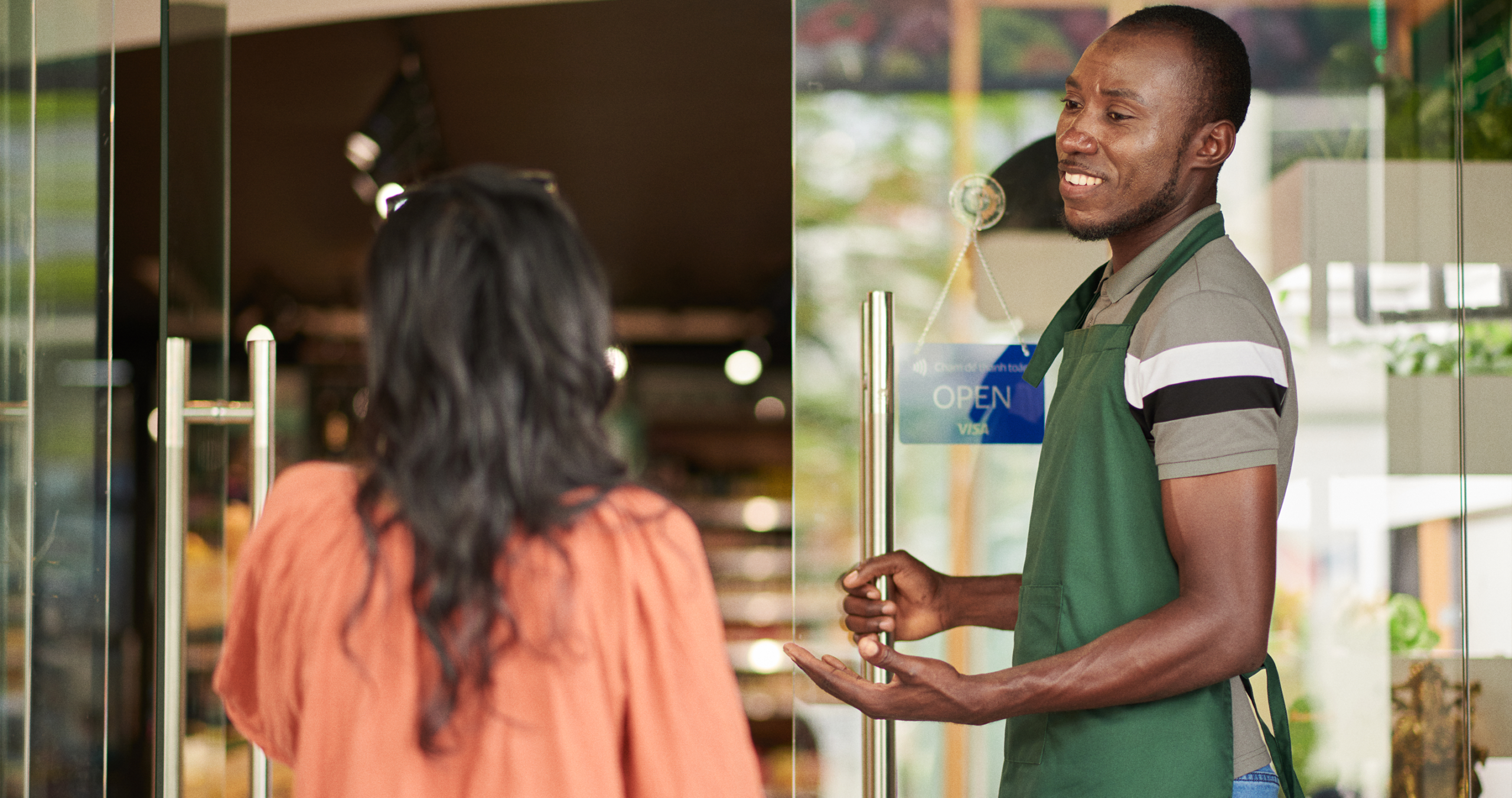 A restaurant staff member helping a customer scan at the till