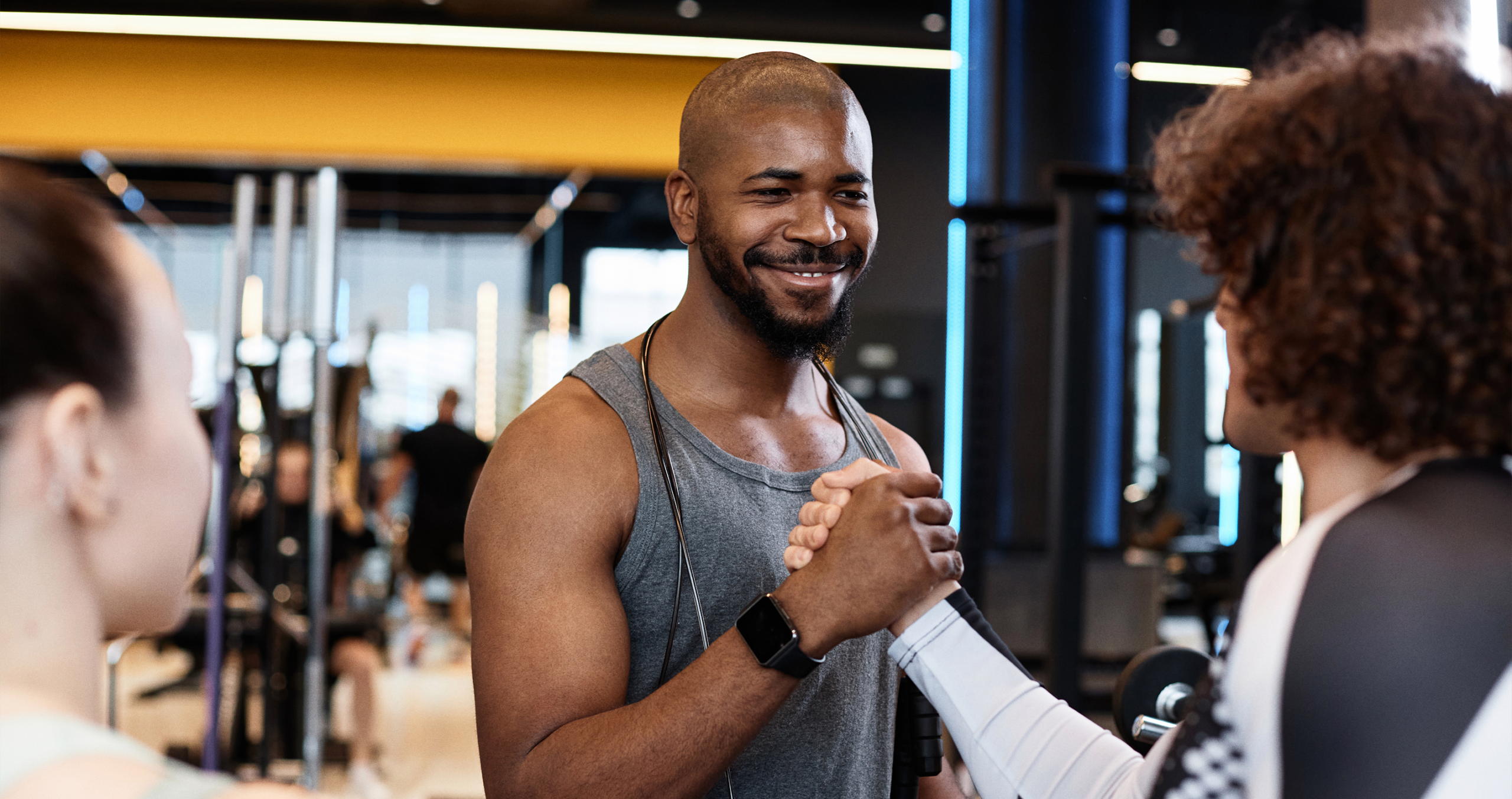 A gym staff member scanning a member's phone at reception
